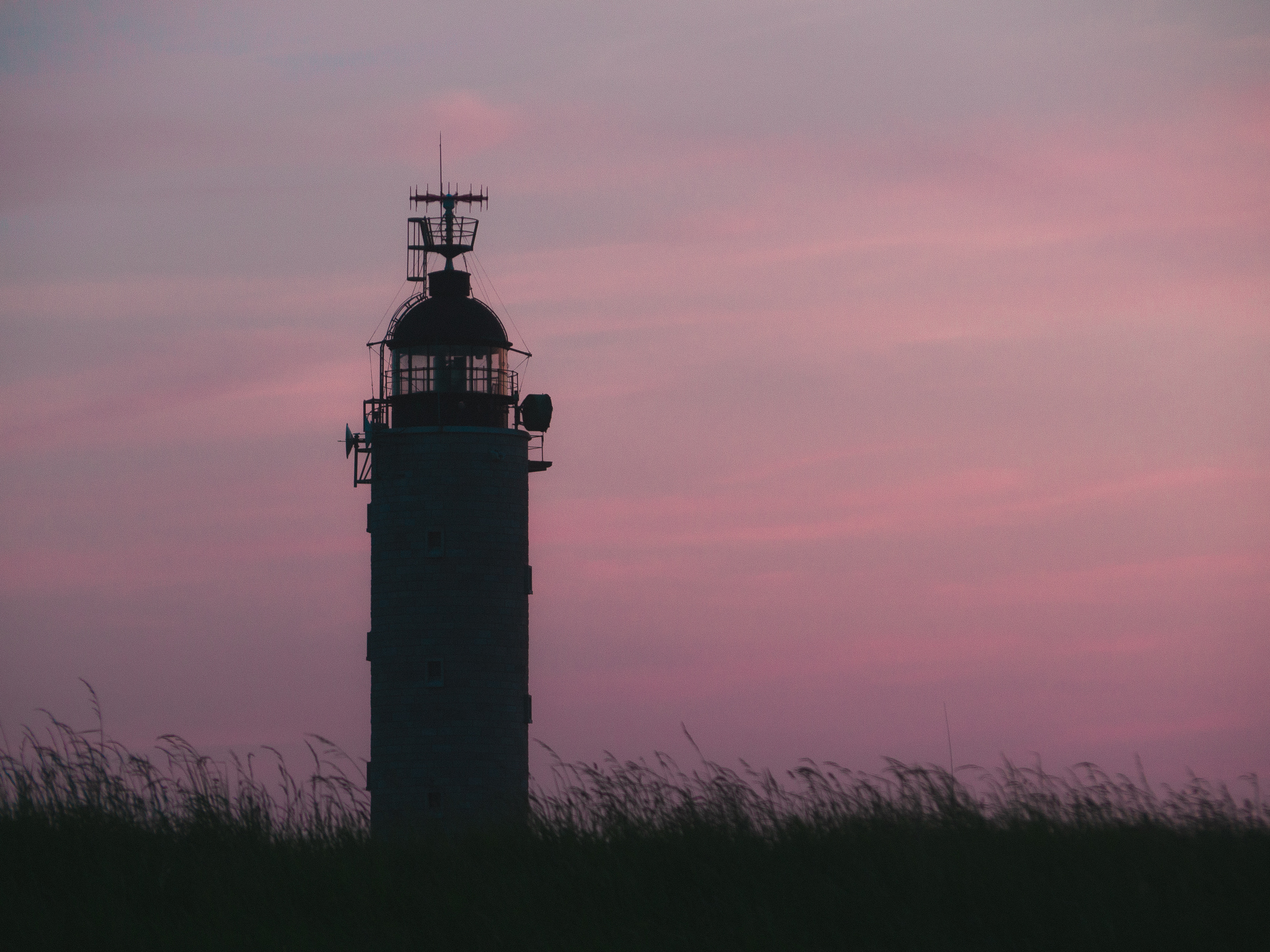 Paysage d'un phare sur une colline en bord de falaise lors du crépuscule
